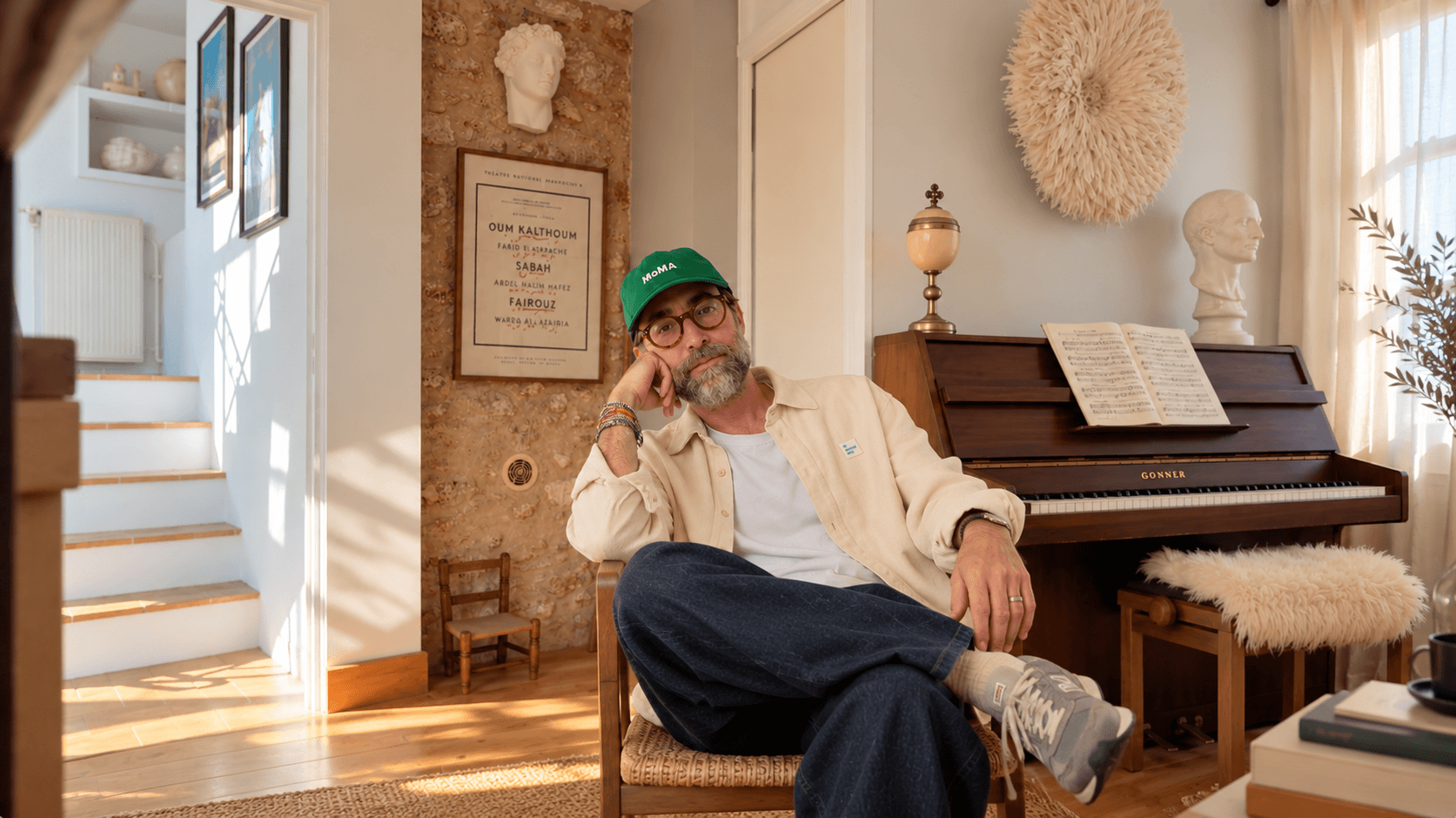 Nicolas assis près d’un piano dans un intérieur lumineux